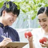 収穫した野菜を見る男女