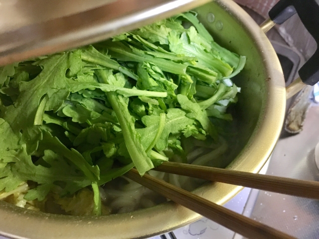 鍋に春菊を入れている様子