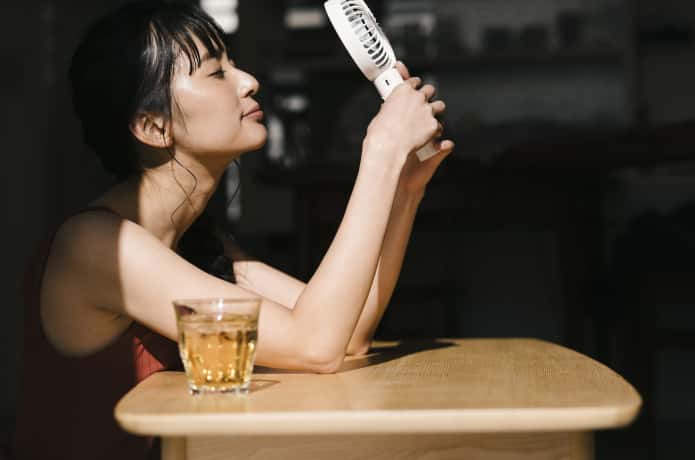 携帯扇風機を使用する女性