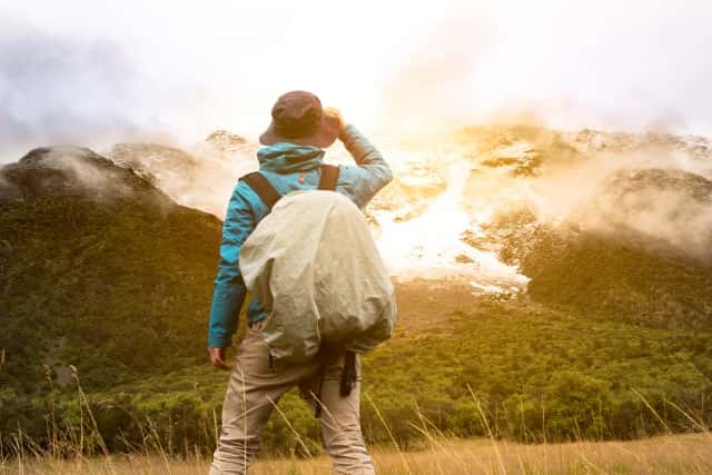 ウィンドブレーカーで登山する男性
