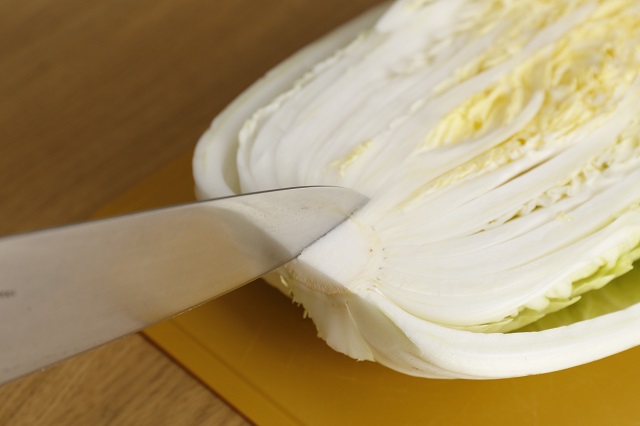 半分に切った白菜に切り込みを入れる